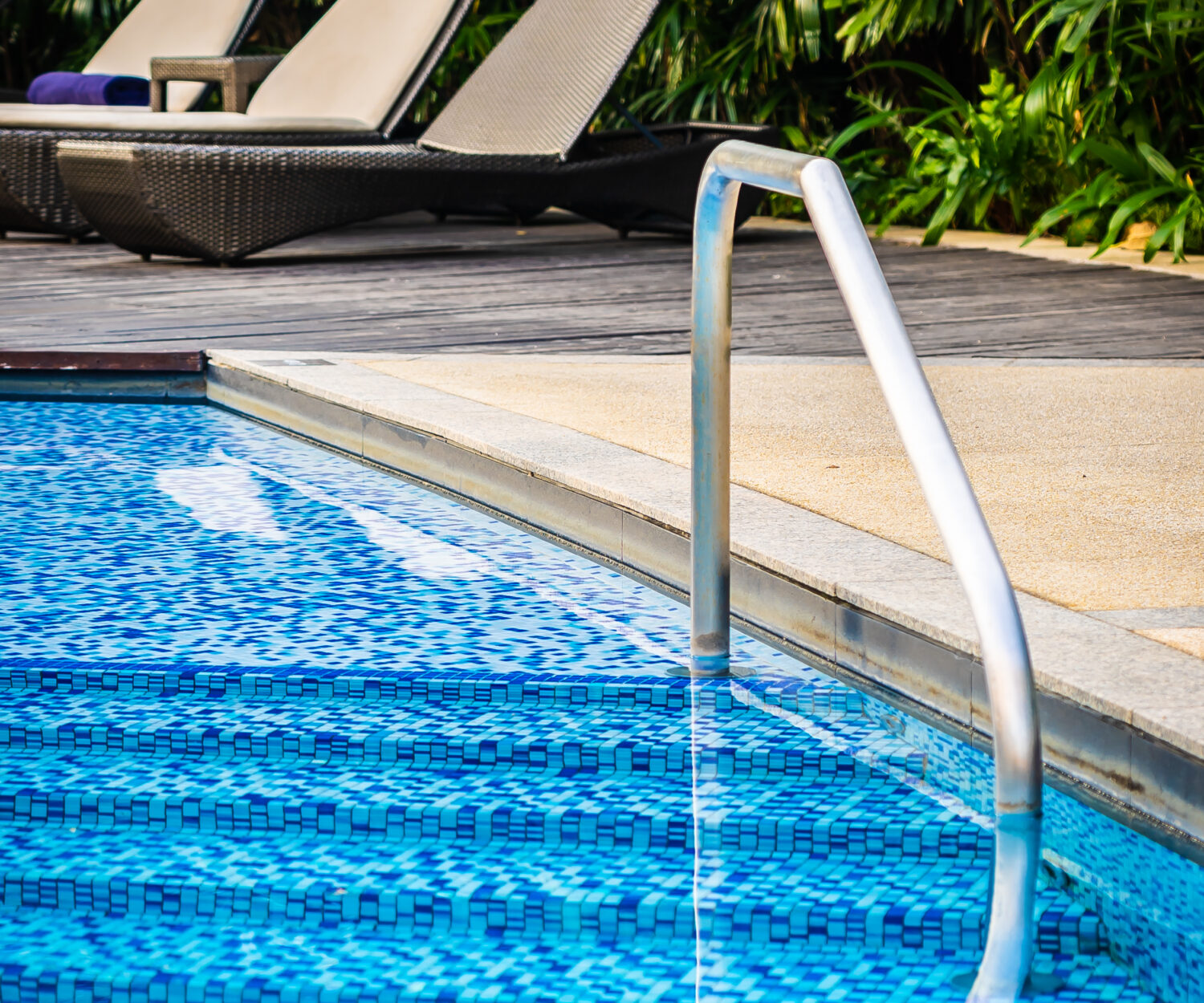 Beautiful outdoor swimming pool with bed deck chair and umbrella in resort for travel and vacation concept